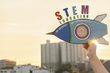 STEM Education concept. Study guide that integrates knowledge Science, Technology, Engineering, Math. Kids are holding a rocket paper, STEM text. Interested to learn new things happily.の写真素材