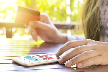 Online shopping concept. Women are buying online with a credit card. Online Shopping Website on Smartphone. There is a message saying shop now is on.の写真素材