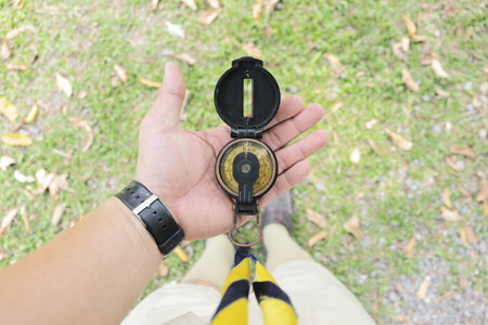 Scouts are using the compass to travel. Put it on your hand for efficient use. The costume is unique to the Boy Scouts. Scouting is a multi-national activity. The background is green lawn.の写真素材