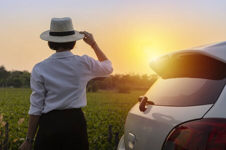 Women are relaxing outside of the white car and looking at the beautiful nature.の写真素材