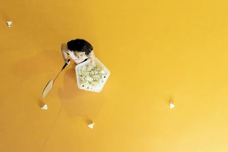 High angle concept, Lovely girls are playing badminton. She is excited to serve badminton on yellow sports ground.の写真素材