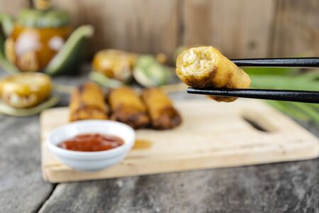 Spring rolls are from Chinese that we have eaten in the Dim Sum menu. The original filling is minced pork vermicelli. Chopsticks are clamping it.の写真素材