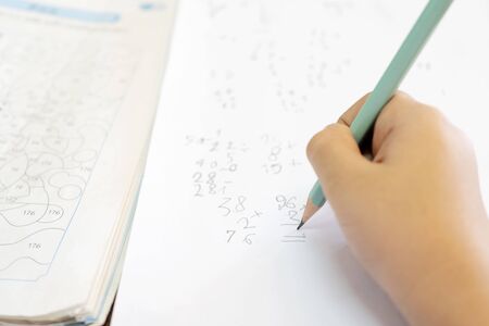 Children are thinking of solving math problems. In the difficulty level of primary school level, Use the pencil to work and have a test on the side.の写真素材