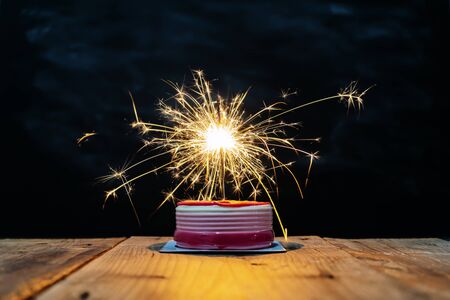 Success celebration concept. The cake on the table has a fireworks that illuminates the light and looks amazing.の写真素材