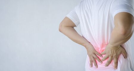 Back pain concept, kidney inflammation, man suffering from backache at home, red inflamed zone,...
