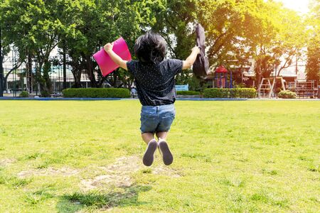 Back to school concept. Girls who travel to study with intention, Jumping cheerfully. She is traveling to study music, with music notes and ukulele.の写真素材