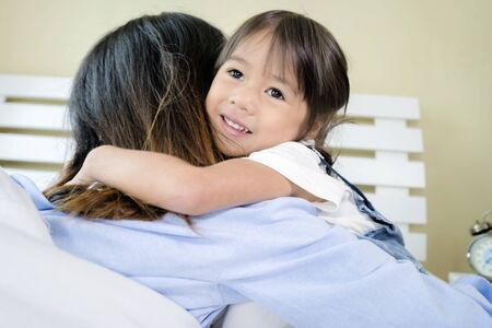 Hug concept. Asian daughters are hugging her mother with great pleasure. In the morning, they hug each other in bed.の写真素材