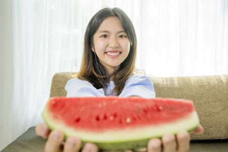 Asian women are eating watermelon, For refreshing in the hot atmosphere.の写真素材