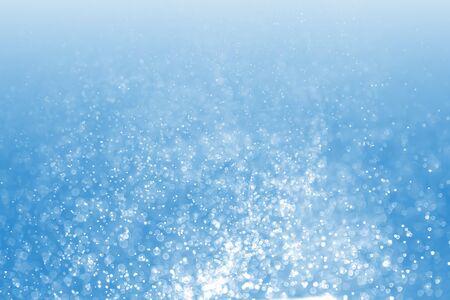 Blue bokeh background. Winter elegant bokeh background. Seasonal cooling light decorative abstract design element.の写真素材