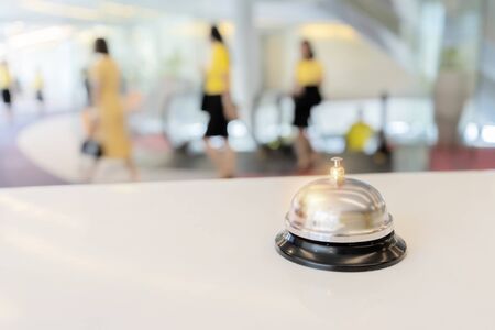 Hotel service bell on a table white glass and simulation hotel background. Concept hotel, travel,...
