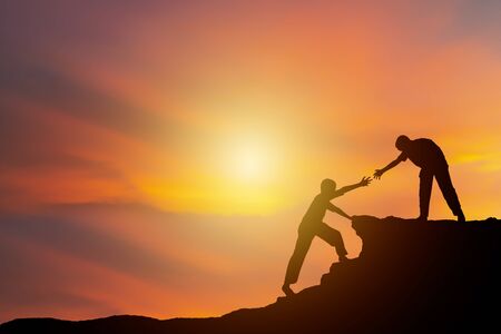 Teamwork isolate concept. Climbing to adventure, a new challenge. I am reaching out to look at that draws more people to the summit as well.の写真素材