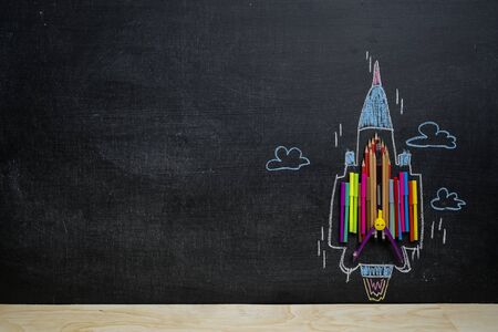 Back to School concept. School supplies, pencils, Magic Color, pens, arranged to resemble the high-speed jets, compared to learning must be encouraged as well. Background blackboard.の写真素材