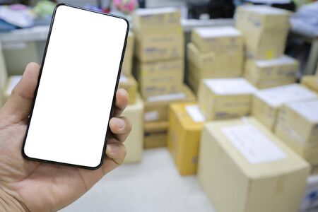 A large number of parcel boxes are ready to be delivered to customers concept. Smartphone, white space to be able to enter text and advertising media.の写真素材