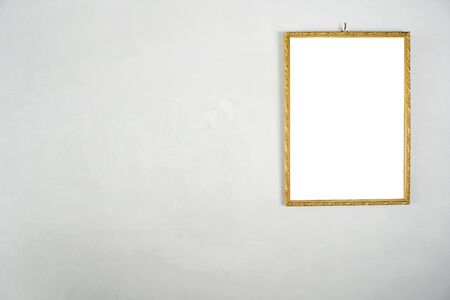 Golden picture frame hanging on a white cement wall.  White label floor for text, images, advertising media.の写真素材