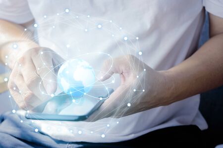 Close up using smartphone to monitor the work. typing text message at social network using cell phone, Graphic, floating globe, light line, trading links, systematic communication.の写真素材