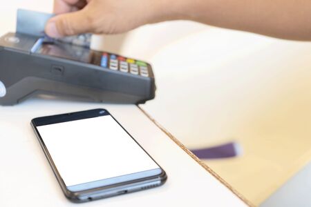Credit card payment, buy and sell products & service, Hand Swiping Credit Card. Moment of payment with a credit card through terminal, Smartphone that is placed in the text.の写真素材