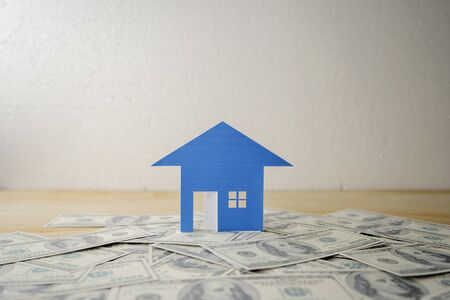 Saving money for real estate with buying a new home and loan for prepare in the future concept. House model grown on dollars, real estate investments concept.の写真素材