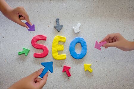 SEO Search Engine Optimization concept. The Plasticine molding that was molded into the SEO alphabet, surrounded by arrows. Arrow handle pointing to SEO.の写真素材