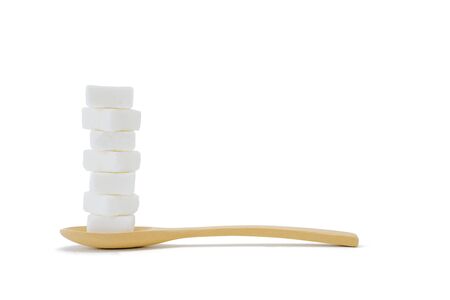 Sugar cubes placed in a wooden spoon, food concept.  backdrop isolated on white background.の写真素材