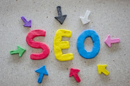 SEO Search Engine Optimization concept. The Plasticine molding that was molded into the SEO alphabet, surrounded by arrows.の写真素材