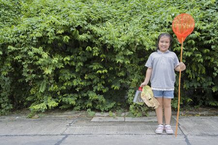 Cute Asian Girls are learning from her adventure with nature, set out to catch insects with sticks containing insect net and cans. Education, Self-learning experience. She is committed concept.の写真素材