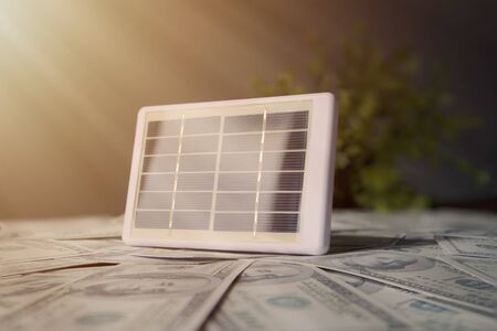 Investment on Renewable Energy concept. Solar panels are located on many dollars, The light of the sun. Renewable energy needed, clean energy to solve global warmingの写真素材