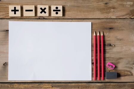 Mathematics concept. Writing utensils and white paper placed on the table, Mathematical symbols, addition, subtraction, multiplication, division.の写真素材