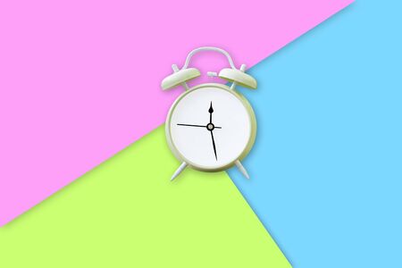 The green alarm clock is placed on a pink, green and blue Patel color. Time concept. Minimal composition. minimal idea business concept.の写真素材