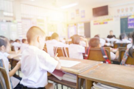 Back to school, education concept. Classroom in blur background young student; Blurry view of elementary class room kid or teacher with chairs and tables in campus.の写真素材