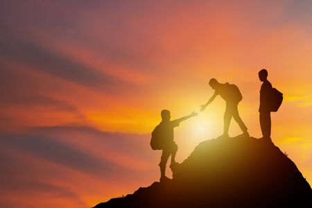 Teamwork isolate concept. Climbing carrying a backpack too adventure, a new challenge. I am reaching out to look at that draws more people to the summit as well. He has assisted as well.の写真素材