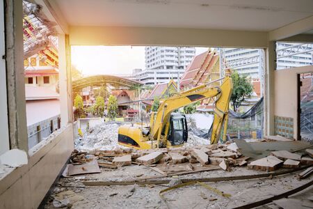 Remains of the destroyed industrial building. Demolished destructed building ruins. the machine is working.の写真素材