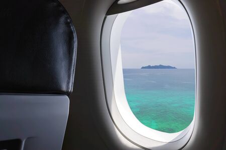 Window View From Passenger Seat On Commercial Airplane. Beautiful view from the window of airplane to blue sky with 
The beautiful blue sea in Thailand.の写真素材