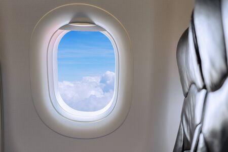 Window View From Passenger Seat On Commercial Airplane. Beautiful view from the window of airplane to blue sky with white clouds at height in sunny day from the passenger seat.の写真素材