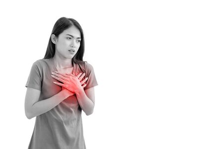 A cute Asian woman is suffering from acute heart disease, showing signs of illness by using her hands to hold her chest. White isolated background, Black and white image with red graphicsの写真素材