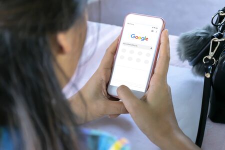 December 31, 2019 Bangkok, Thailand : Asian woman is typing on Google search engine from a smartphone. Google is the biggest Internet search engine in the world.のeditorial素材