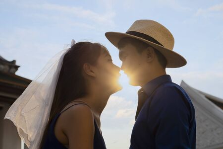 Close-up of young asian romantic couple is kissing and enjoying the company of each other in the park. Tend to get marriedの写真素材
