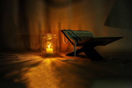 Islam holy book of Muslims, The Quran is placed on a wooden stand. Light candles.の写真素材