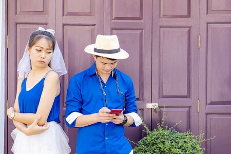 Asian couples, women who are touchy for men because men are addicted to smartphones too muchの写真素材