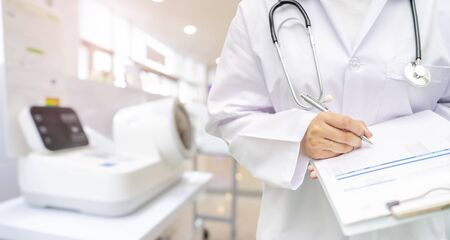 Woman doctor examination at hospital office, close-up. Therapist filling up medication history records. Medicine and healthcare conceptの写真素材