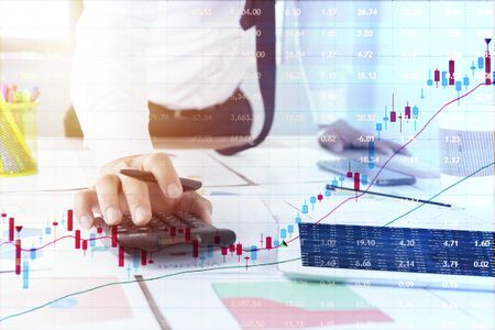 business documents on office table with smart phone and digital tablet and graph financial with social network diagram and man working in the backgroundの写真素材