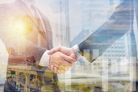 Double exposure of business handshake for successful of investment deal and Twilight view cityscape background, teamwork and partnership concept.の写真素材