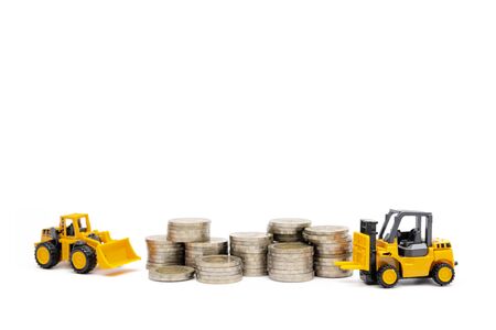 Concepts of financial business investment, Numerous coins stacked and crane and forklift models, White isolated backgroundの写真素材