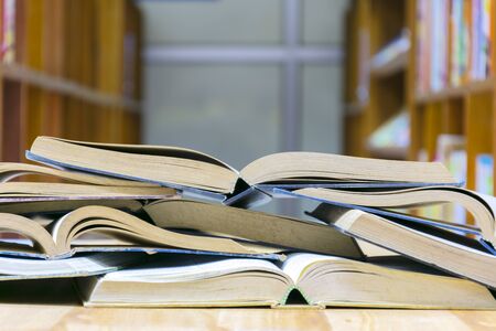 A lot of books were stacked on the library table. Education is the amount of knowledge that we can learn throughout.の写真素材