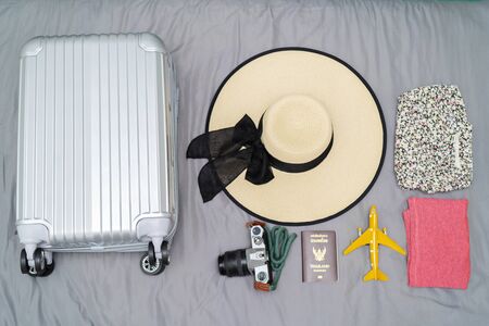 Flat silver bag, Camera, clothing, sombrero, Passport Thailand, put travel accessories on a bright gray bed background. Tourism conceptの写真素材