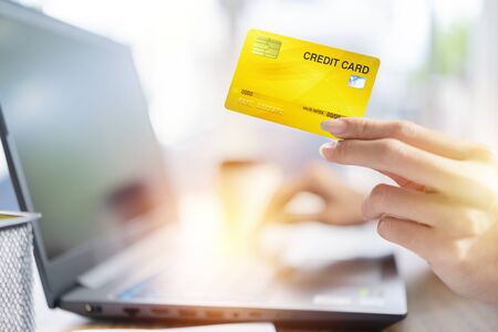 Hands holding credit card and using laptop. Online shopping, e-commerce, internet banking, spending money, working from home conceptの写真素材