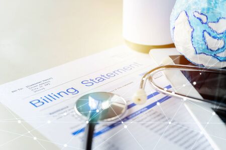 Health care billing statement, globe with stethoscope, bottle of medicine for doctor's work in medical center stone background.の写真素材