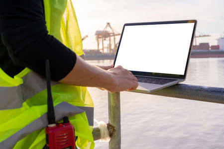 An engineer is using a tablet to work, she is at the shipping dock. Use radio communication for notifications and work orders.の写真素材