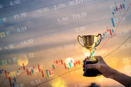 Business people hold trophies. Investment Consultant, Achieved financial investment, won the stock marketの写真素材