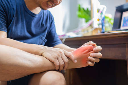 Man with painful and inflamed gout on his foot around the big toe area.の写真素材