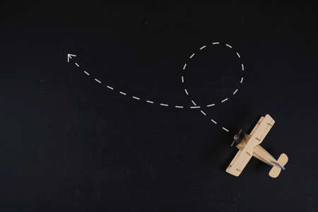 Travel destination concept. A wooden airplane model placed on a black board groundの写真素材